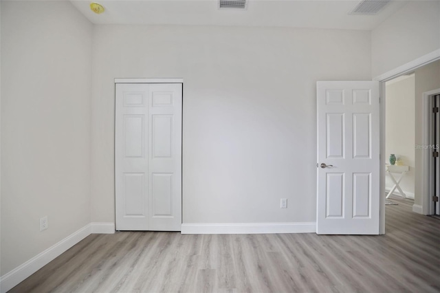 unfurnished bedroom featuring a closet and light wood-type flooring