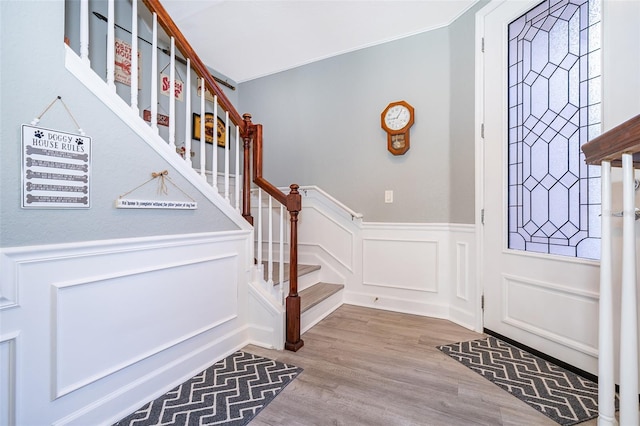 entryway with light wood-type flooring and ornamental molding