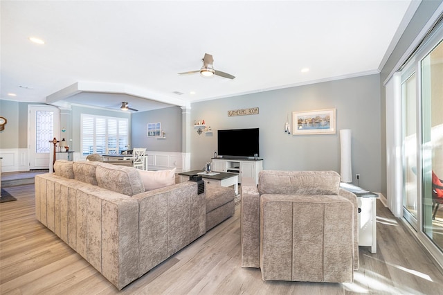 living room featuring light wood-type flooring, decorative columns, ceiling fan, and ornamental molding