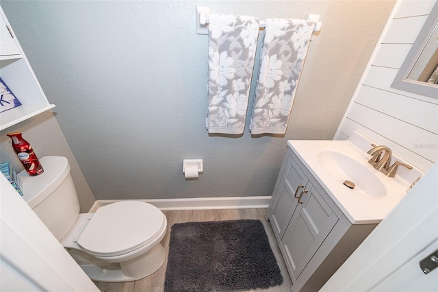 bathroom with vanity, toilet, and wood-type flooring