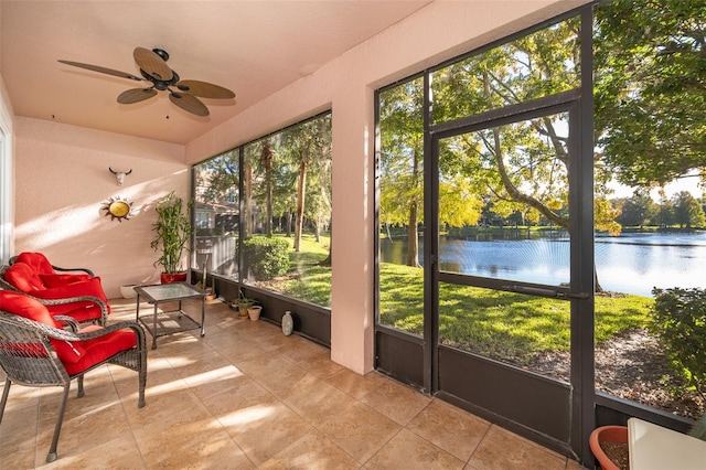 sunroom / solarium with a water view and ceiling fan