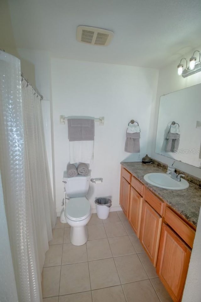 bathroom featuring tile patterned flooring, vanity, and toilet