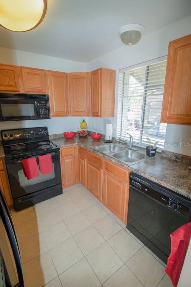 kitchen with light tile patterned flooring, sink, and black appliances