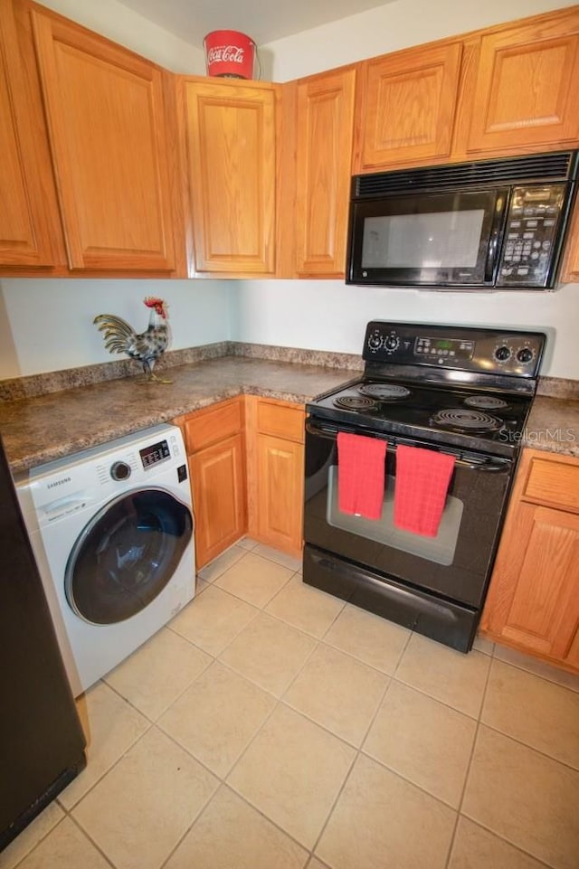 kitchen with black appliances, light tile patterned flooring, and washer / clothes dryer