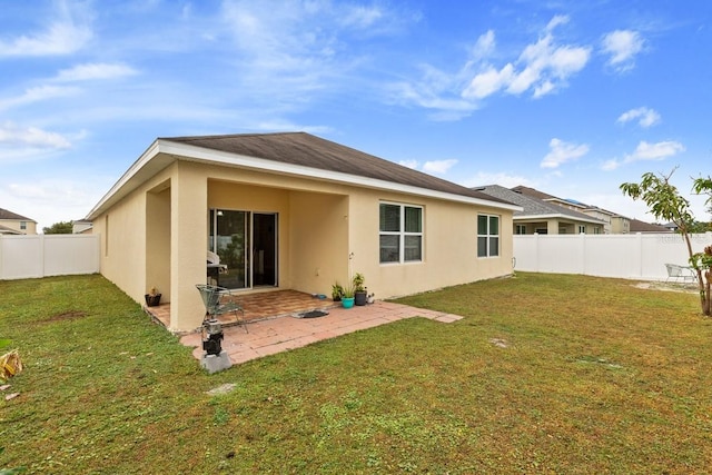 back of house featuring a yard and a patio