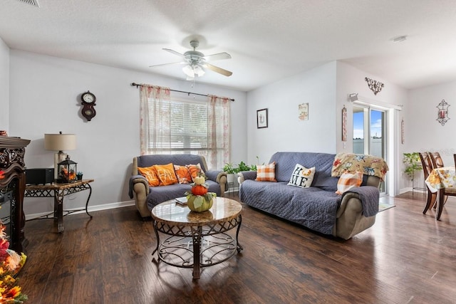 living room with ceiling fan, dark hardwood / wood-style flooring, and a textured ceiling