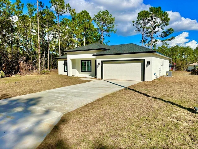 prairie-style home with central AC unit and a garage