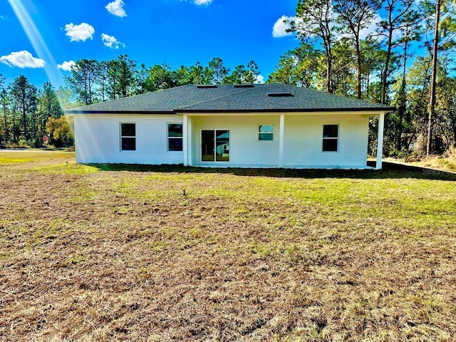 rear view of property featuring a lawn