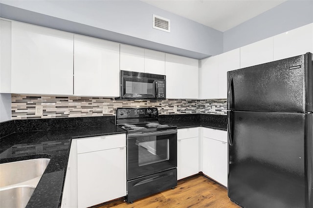 kitchen featuring white cabinets, light hardwood / wood-style floors, and black appliances