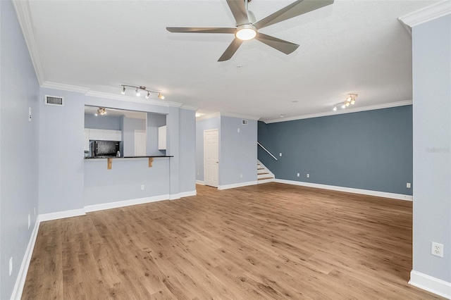 unfurnished living room featuring hardwood / wood-style floors, ceiling fan, and crown molding