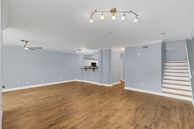 unfurnished living room featuring ceiling fan, hardwood / wood-style floors, and crown molding