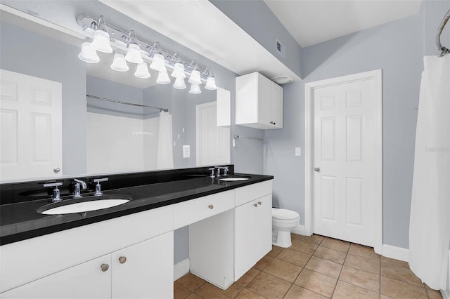 bathroom featuring tile patterned flooring, vanity, toilet, and walk in shower