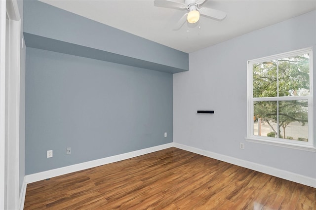 empty room featuring a healthy amount of sunlight, ceiling fan, and wood-type flooring