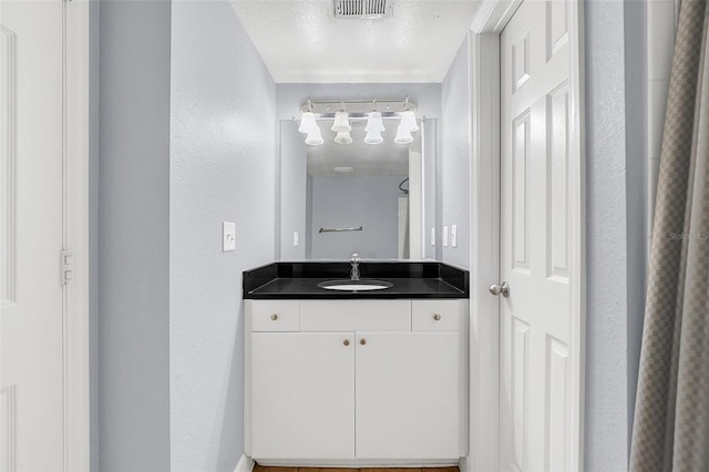 bathroom featuring vanity and a textured ceiling