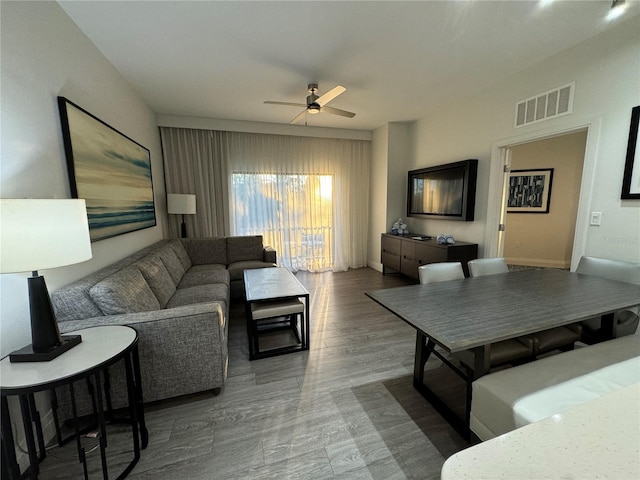 living room featuring hardwood / wood-style floors and ceiling fan