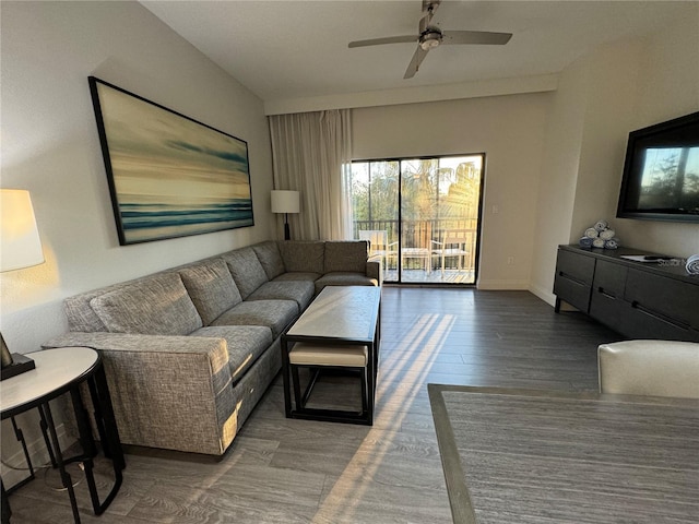 living room with ceiling fan and dark wood-type flooring