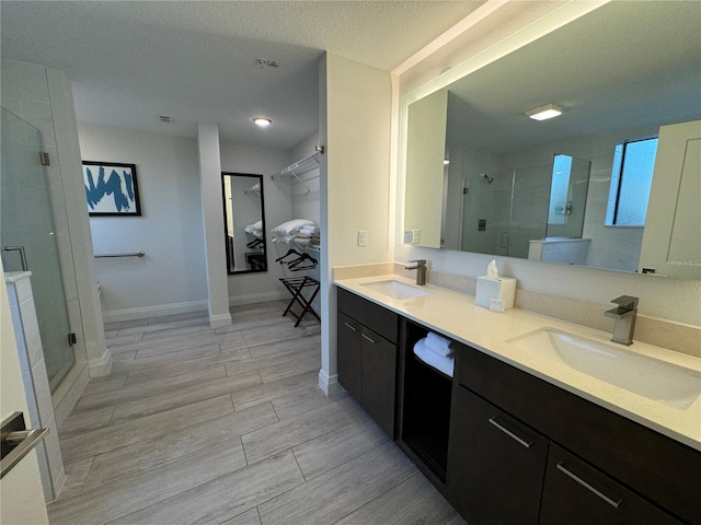 bathroom featuring vanity, an enclosed shower, and a textured ceiling