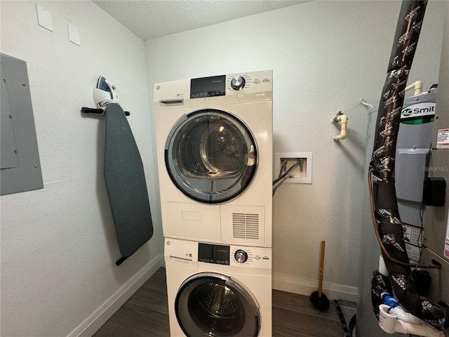 washroom featuring a textured ceiling, dark hardwood / wood-style flooring, electric panel, and stacked washer / drying machine