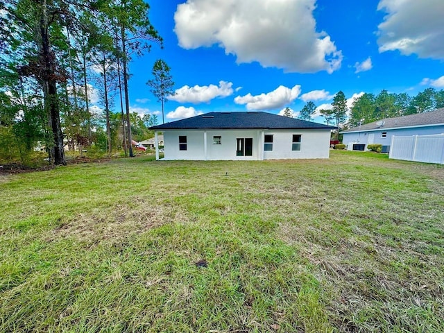 rear view of property with a yard