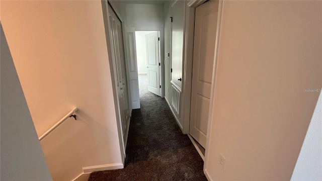 hallway featuring dark carpet