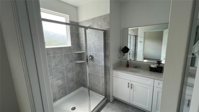 bathroom featuring tile patterned flooring, vanity, and a shower with door