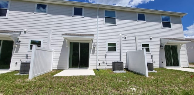 rear view of property with central AC and a yard