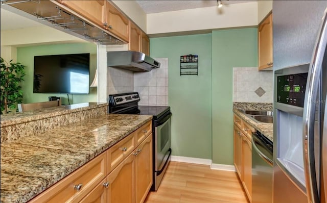 kitchen featuring decorative backsplash, ventilation hood, stainless steel appliances, stone countertops, and light hardwood / wood-style floors