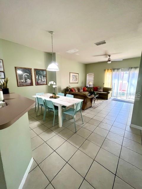 tiled dining space with ceiling fan