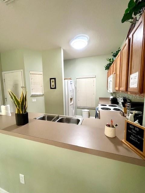 kitchen featuring white appliances and sink