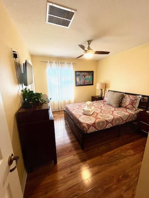 bedroom with ceiling fan and dark wood-type flooring