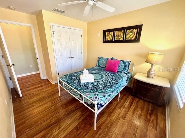 bedroom with ceiling fan, a closet, and wood-type flooring