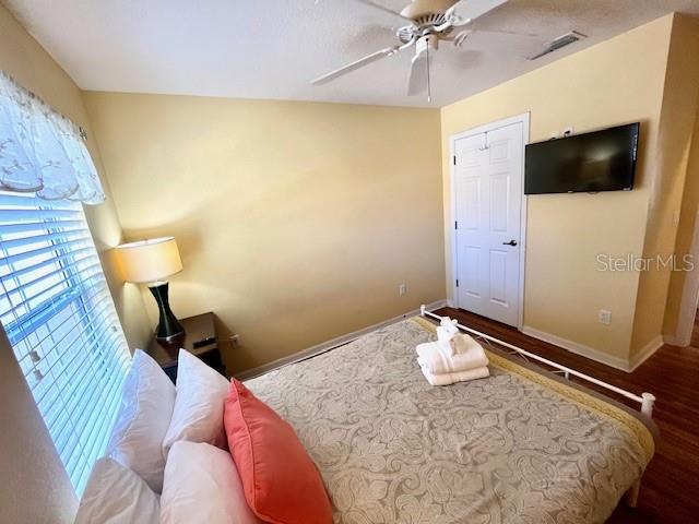 bedroom with ceiling fan, wood-type flooring, and vaulted ceiling