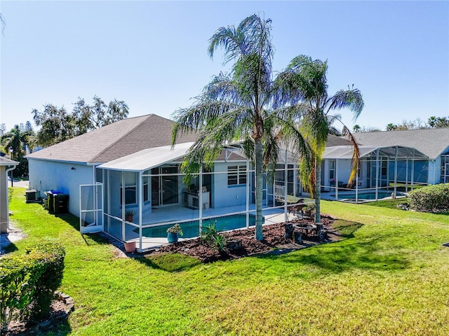 rear view of house featuring a lanai, a yard, and a patio