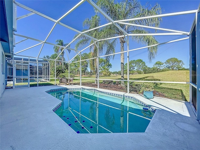 view of pool featuring a patio area, a yard, and glass enclosure