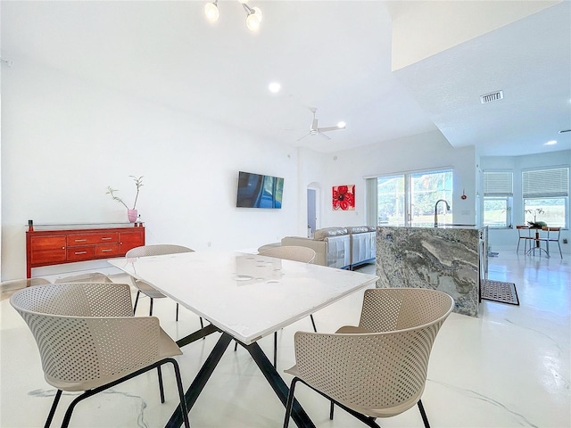 dining space with ceiling fan and sink