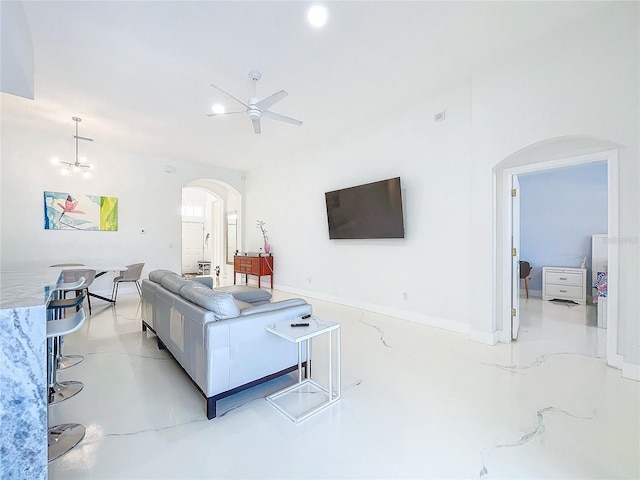 living room featuring ceiling fan with notable chandelier