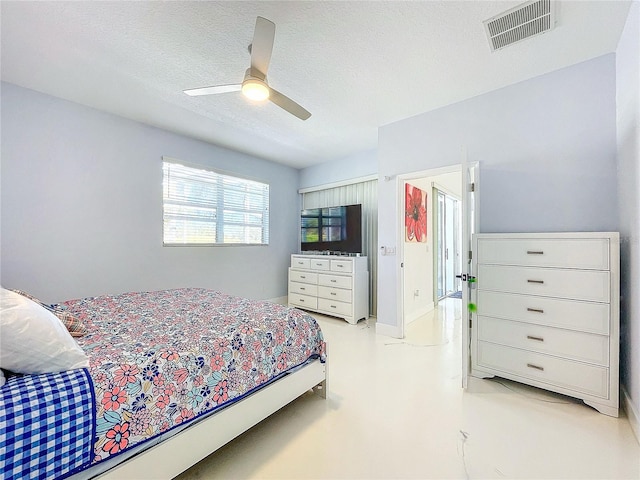 bedroom featuring ceiling fan and a textured ceiling