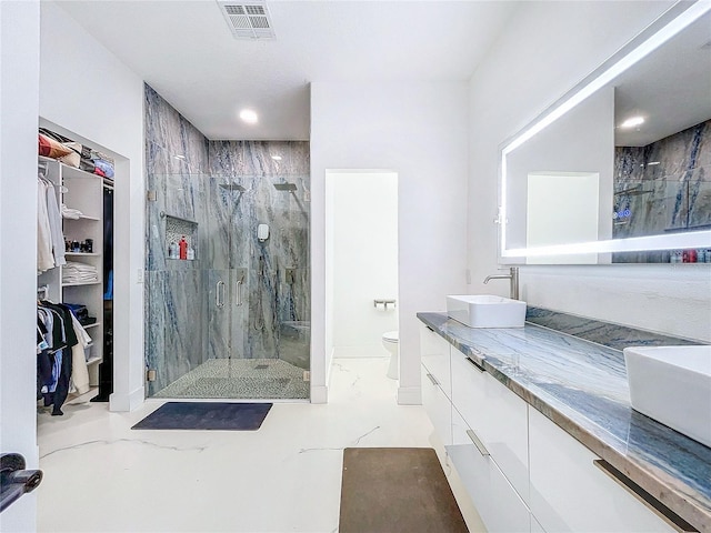 bathroom with vanity, toilet, and a shower with shower door