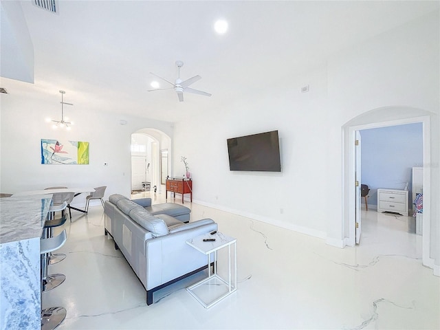 living room with ceiling fan with notable chandelier