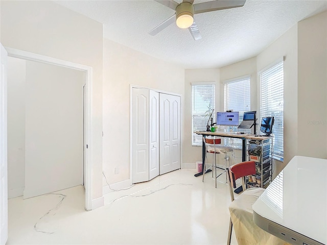 office space with ceiling fan, a textured ceiling, and concrete floors