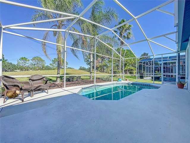 view of pool with a patio and glass enclosure