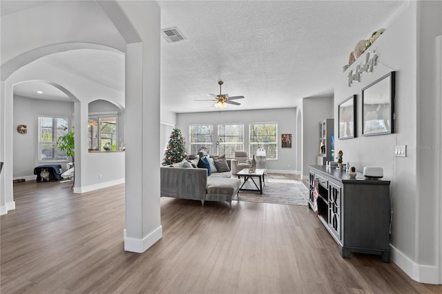 living room with wood-type flooring, a textured ceiling, and ceiling fan