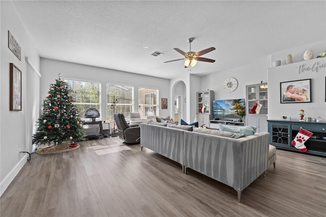 living room with wood-type flooring, a textured ceiling, and ceiling fan