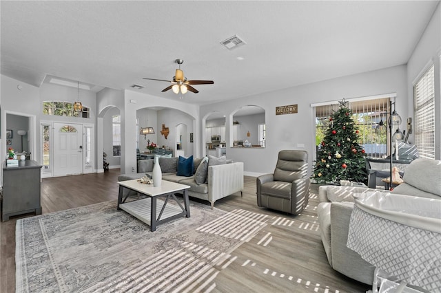 living room with hardwood / wood-style floors, a textured ceiling, ceiling fan, and lofted ceiling