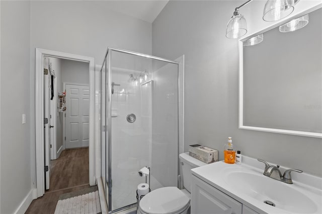 bathroom with vanity, toilet, wood-type flooring, and a shower with shower door