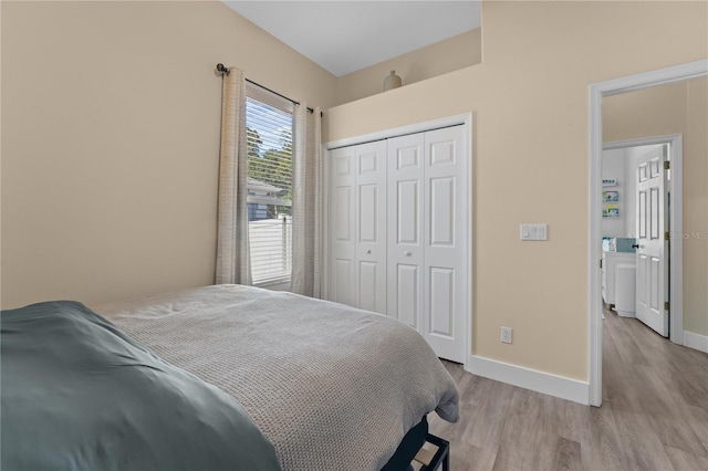 bedroom with light hardwood / wood-style floors and a closet