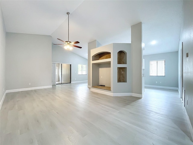 unfurnished living room with ceiling fan, lofted ceiling, and light wood-type flooring