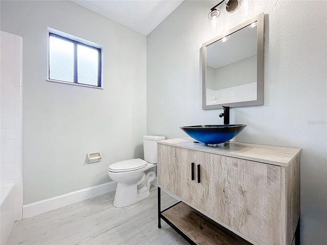 full bathroom featuring vanity, a textured ceiling, shower / washtub combination, wood-type flooring, and toilet