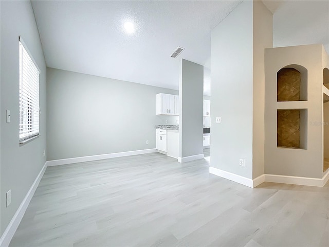 unfurnished living room with light hardwood / wood-style floors and a textured ceiling