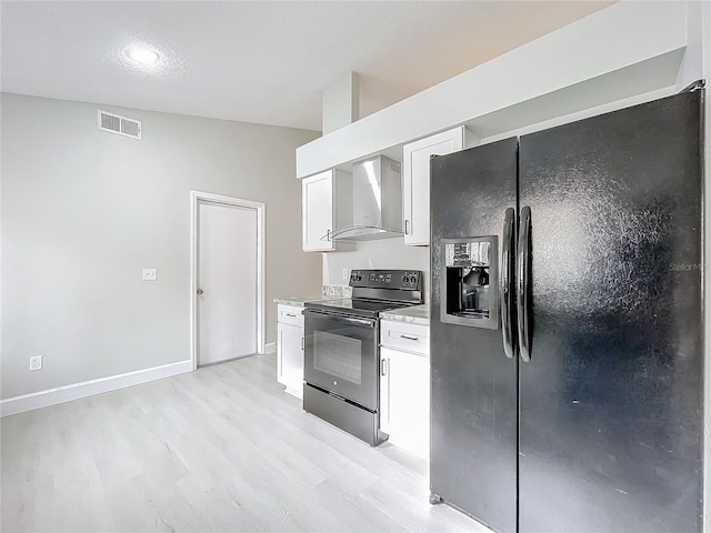 kitchen featuring vaulted ceiling, wall chimney range hood, black appliances, light hardwood / wood-style floors, and white cabinetry